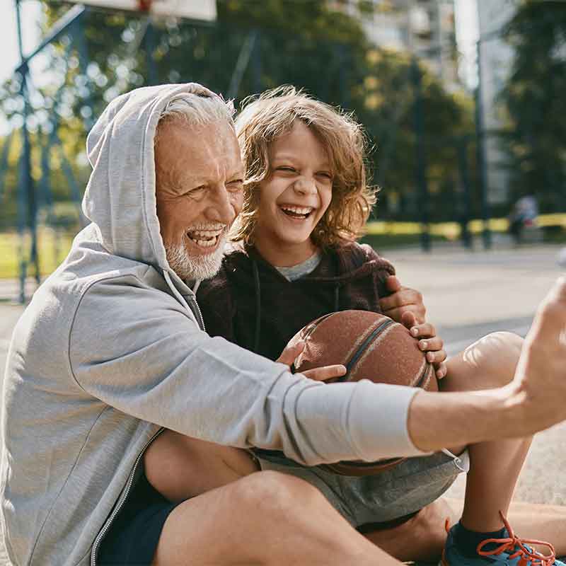 Grandfather and grandson taking a break from playing basketball to take a selfie