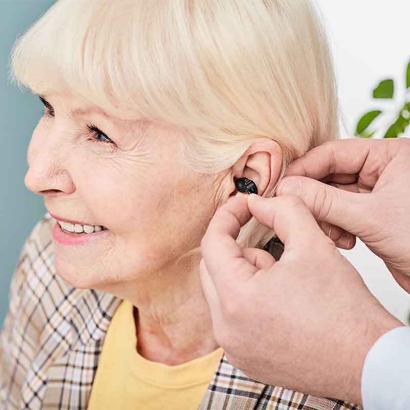 Woman being fitted with a discreet hearing aid