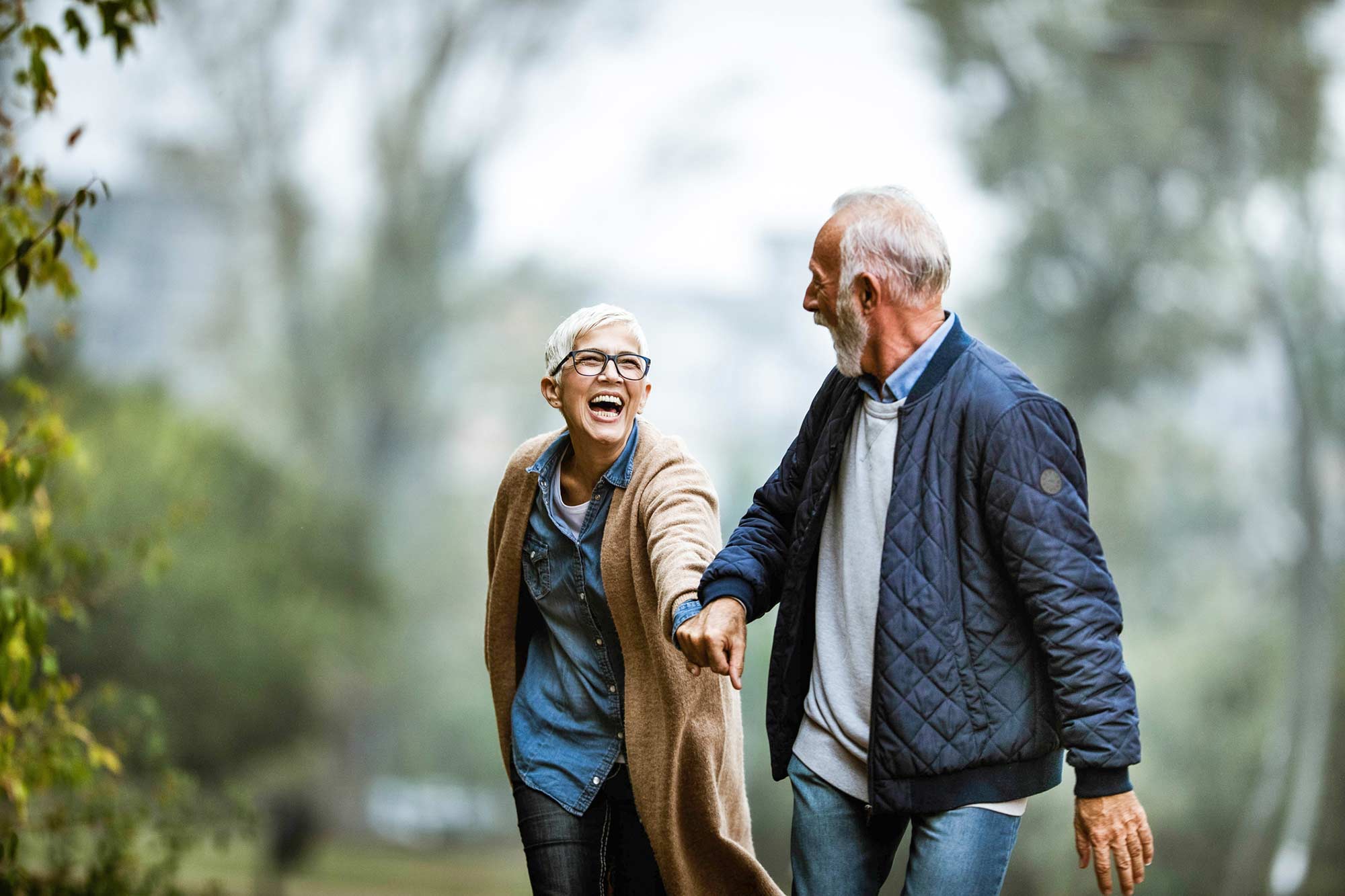 Couple laughing and holding hands on a walk